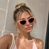 Blush Pink | Occhiali da Sole Cat-Eye WYNIE Rosa Pastello, indossati da una ragazza bionda con outfit estivo minimal