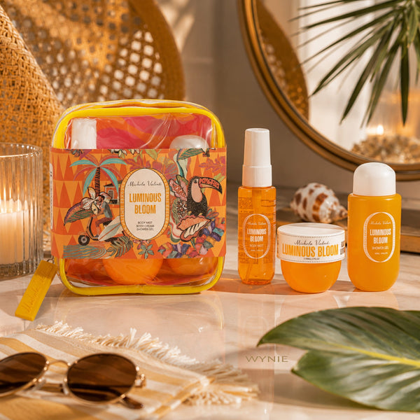 Michela Valenti Luminous Bloom Set Profumato | Body Mist, Crema Corpo e Doccia Schiuma dalla profumazione agrumata con Pochette in PVC giallo arancio e scena luxury aesthetic con dettagli estivi